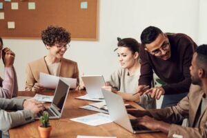 digital literacy: imagem mostra colaboradores em torno de uma mesa em ambiente corporativo